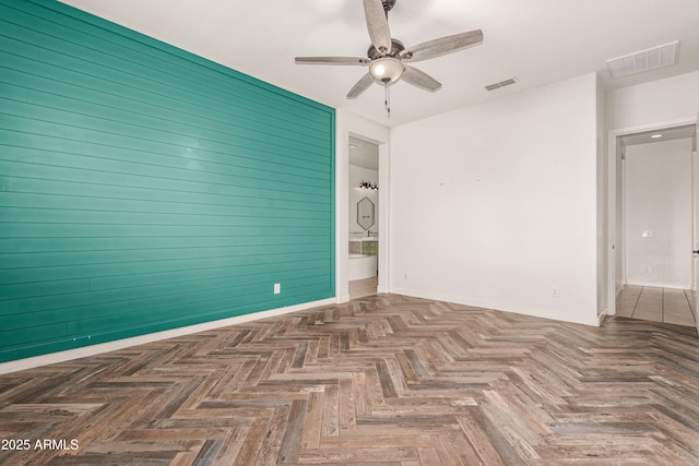 unfurnished room with ceiling fan and dark parquet floors