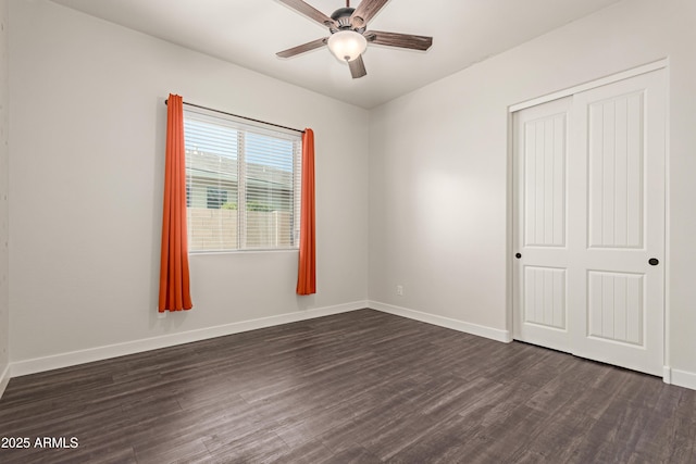 unfurnished bedroom with ceiling fan, dark hardwood / wood-style floors, and a closet