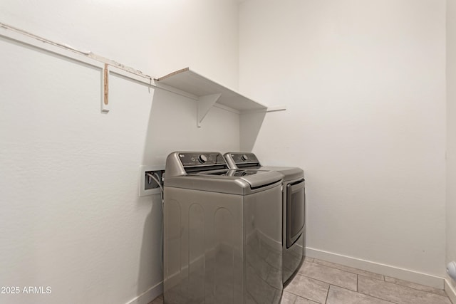 washroom with light tile patterned floors and washing machine and clothes dryer