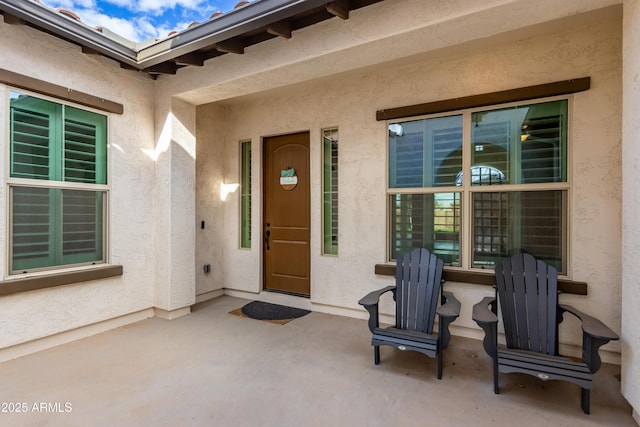 view of exterior entry with a patio