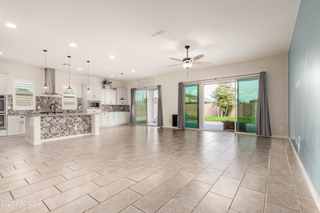 unfurnished living room with ceiling fan and sink