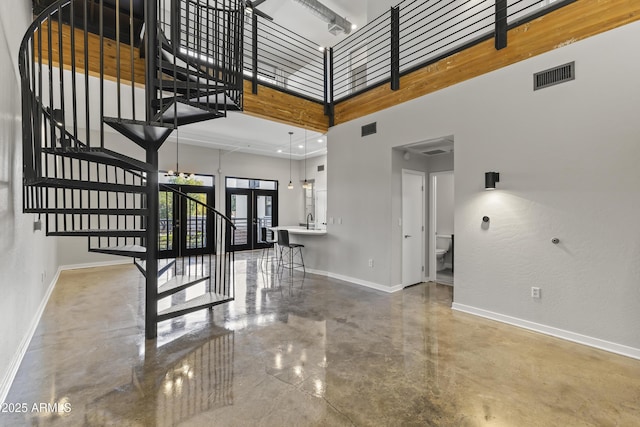 stairs with french doors, a towering ceiling, and sink