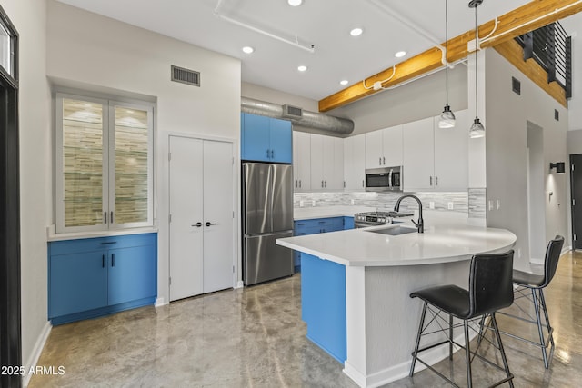 kitchen featuring blue cabinets, a breakfast bar area, white cabinetry, hanging light fixtures, and stainless steel appliances