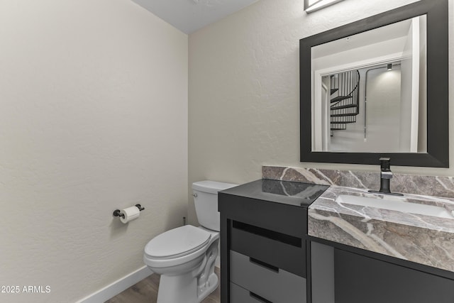 bathroom with vanity, toilet, and hardwood / wood-style floors