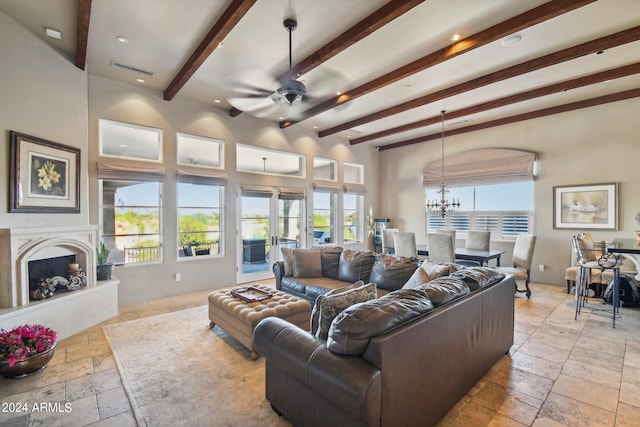 living room featuring ceiling fan with notable chandelier and beam ceiling