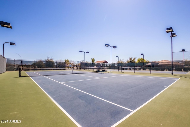 view of tennis court with basketball hoop