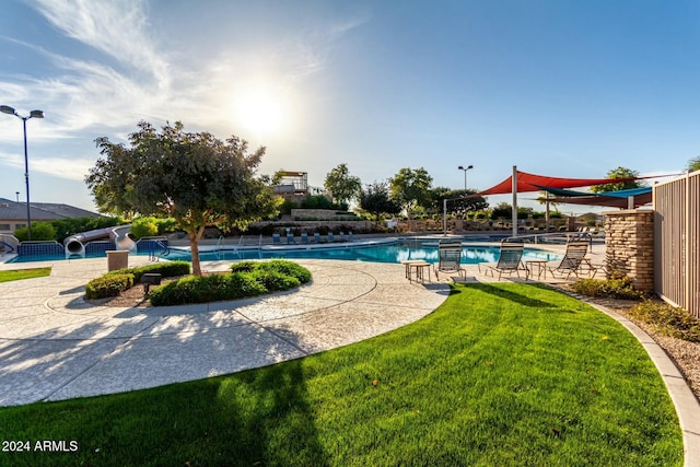 view of pool with a lawn, a patio area, and a water slide