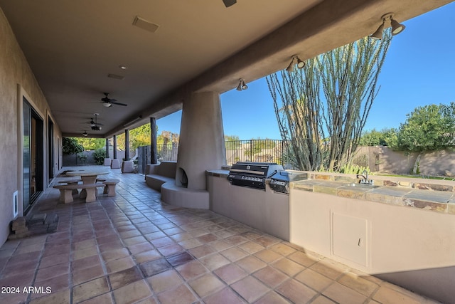 view of patio with area for grilling, sink, and ceiling fan