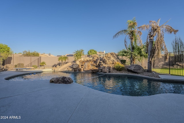 view of pool featuring a diving board and a water slide