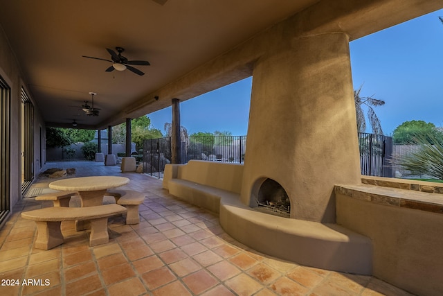 view of patio with a large fireplace and ceiling fan