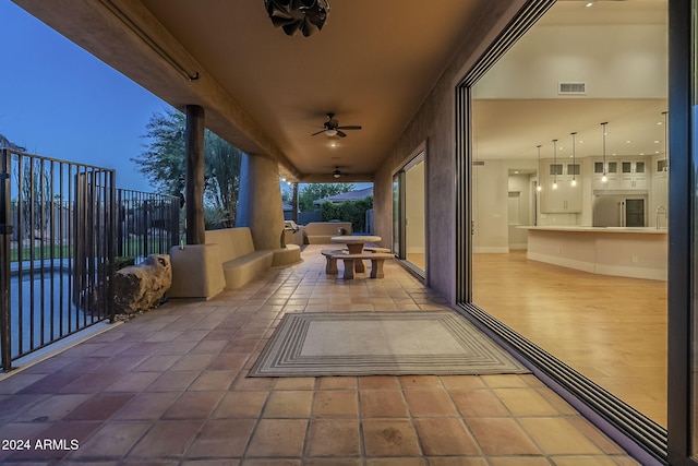 patio terrace at dusk featuring ceiling fan