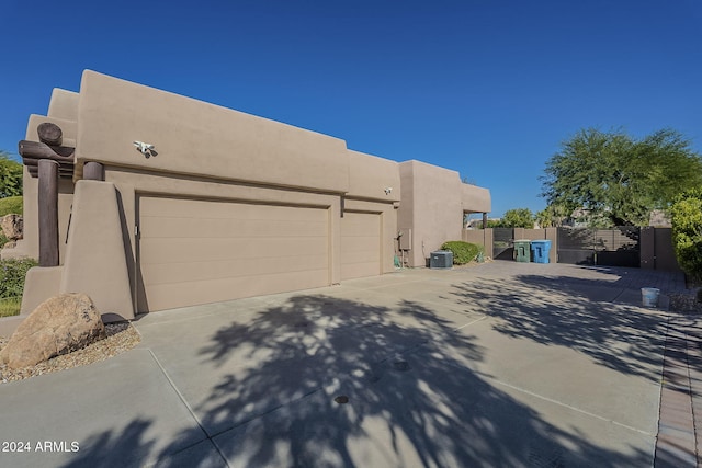 view of side of home featuring central AC unit and a garage