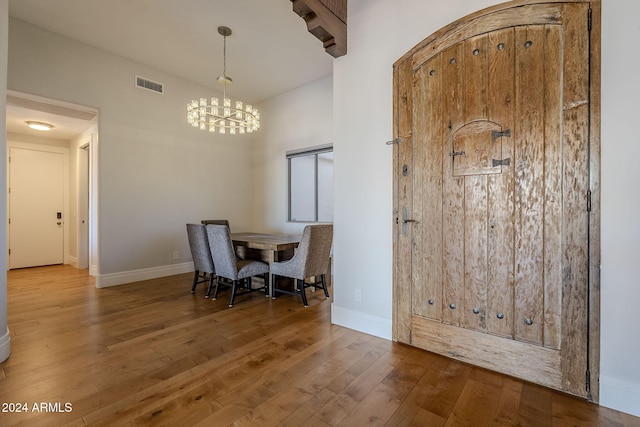 dining space with hardwood / wood-style flooring and an inviting chandelier