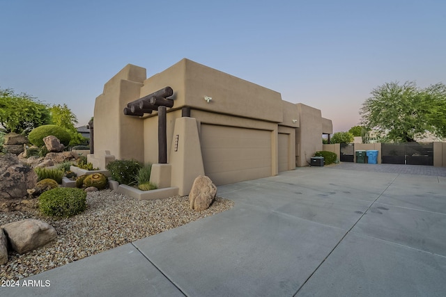 24005 N 45th Dr, Glendale, AZ 85310 - adobe home with an attached garage, concrete driveway, and a gate