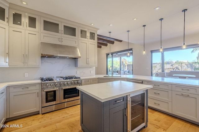 kitchen featuring beverage cooler, range with two ovens, light hardwood / wood-style flooring, and sink