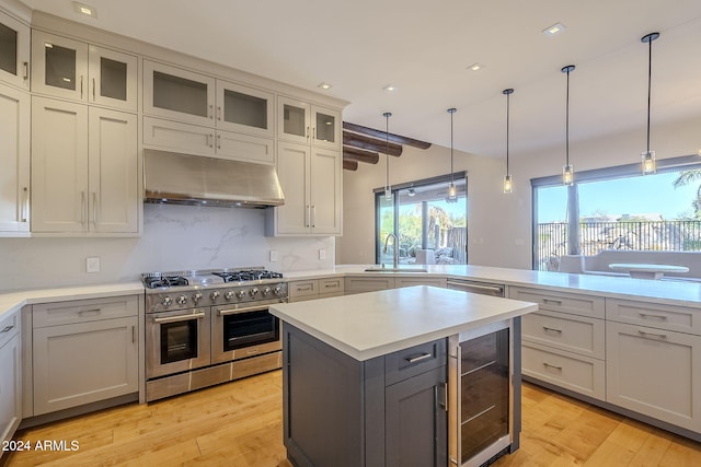 24005 N 45th Dr, Glendale, AZ 85310 - kitchen with range with two ovens, under cabinet range hood, beverage cooler, a sink, and light countertops