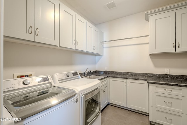 laundry area featuring cabinets, sink, washer and dryer, and light tile patterned flooring