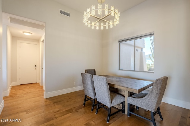 dining space with a chandelier and light hardwood / wood-style flooring