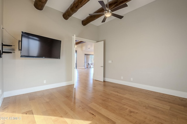 unfurnished living room featuring light wood-type flooring, beamed ceiling, ceiling fan, and high vaulted ceiling