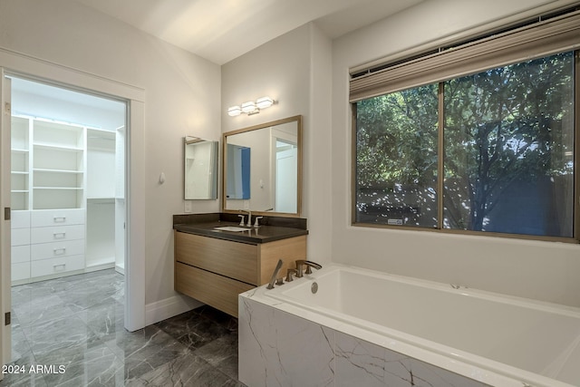 bathroom with vanity and tiled tub