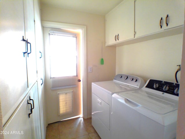 laundry room with separate washer and dryer, light tile patterned floors, and cabinets