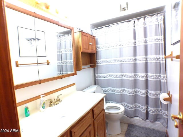 bathroom featuring vanity, toilet, and curtained shower