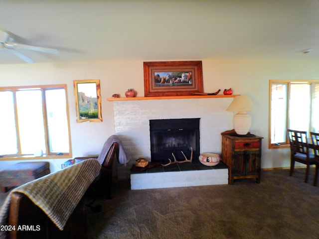 living room featuring a tile fireplace, carpet floors, a wealth of natural light, and ceiling fan