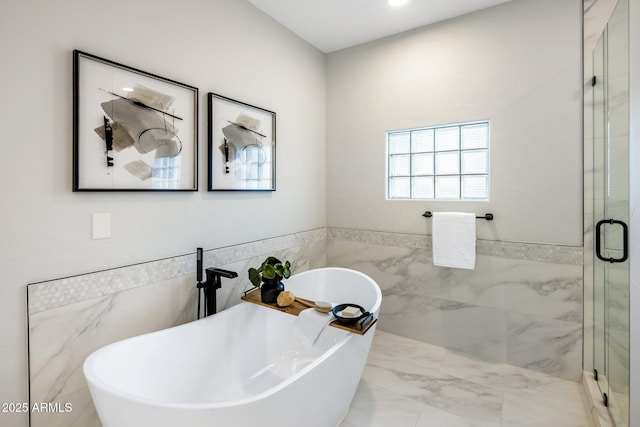 bathroom featuring tile walls and separate shower and tub