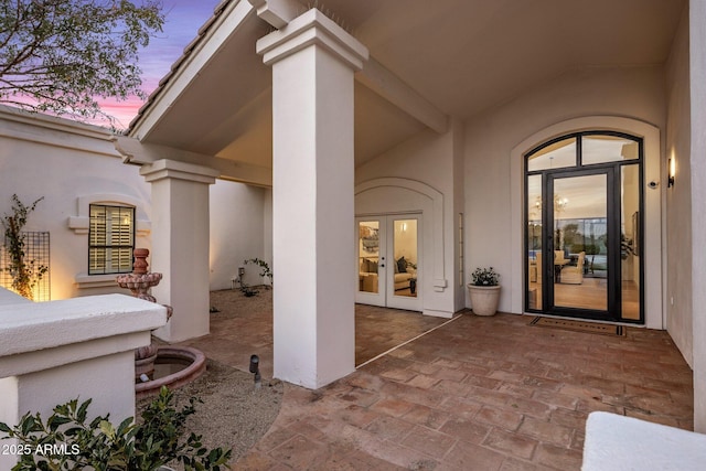 patio terrace at dusk featuring french doors