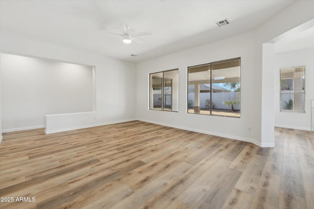 unfurnished room featuring visible vents, a ceiling fan, light wood-style flooring, and baseboards