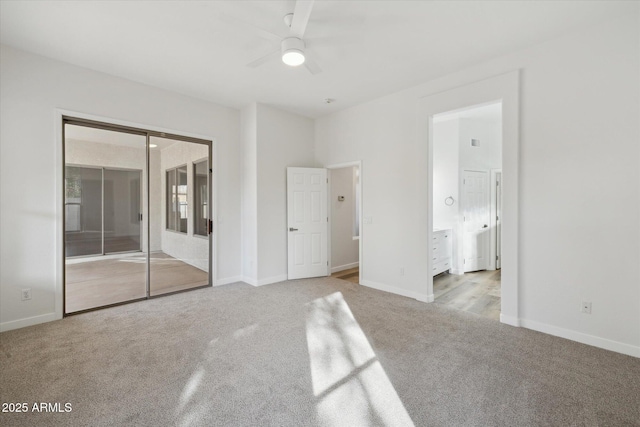 unfurnished bedroom with a closet, light colored carpet, baseboards, and ensuite bathroom