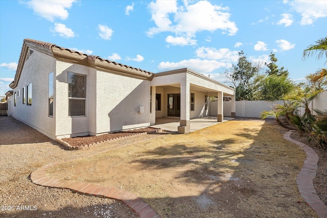 back of house featuring a patio area, a fenced backyard, a tiled roof, and stucco siding