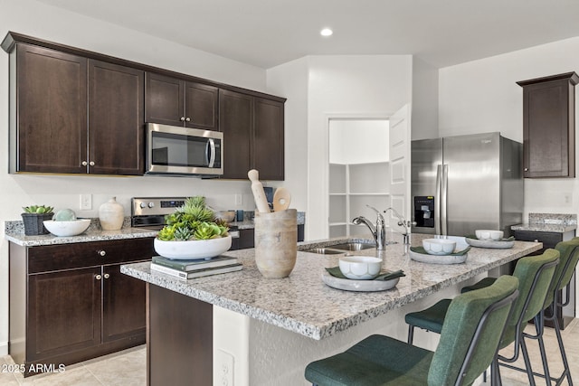 1342 W Hess Ave, Coolidge, AZ 85128 - kitchen with appliances with stainless steel finishes, a sink, dark brown cabinetry, a kitchen breakfast bar, and recessed lighting