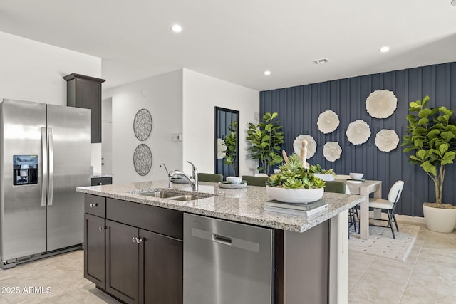 1342 W Hess Ave, Coolidge, AZ 85128 - kitchen with appliances with stainless steel finishes, a sink, an accent wall, light stone counters, and recessed lighting