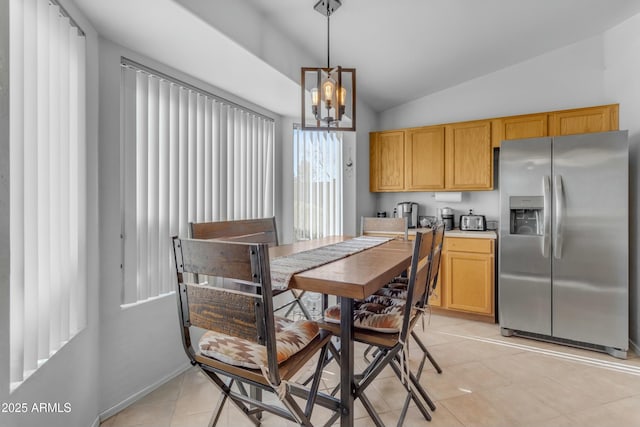 kitchen featuring vaulted ceiling, stainless steel fridge with ice dispenser, light tile patterned floors, pendant lighting, and an inviting chandelier