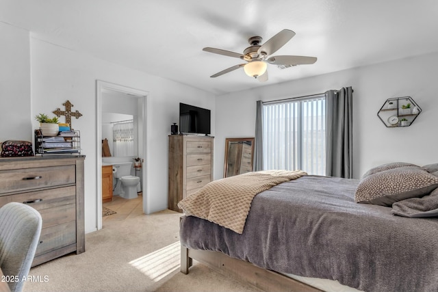 bedroom featuring ensuite bathroom, light carpet, and ceiling fan