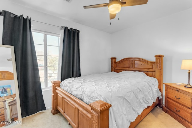 bedroom featuring ceiling fan, light carpet, and multiple windows