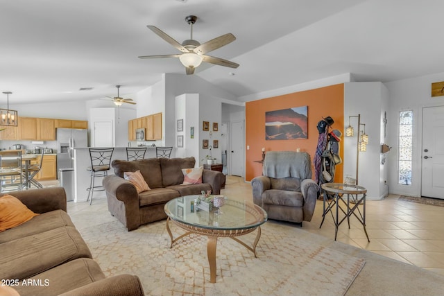 tiled living room featuring ceiling fan with notable chandelier and vaulted ceiling