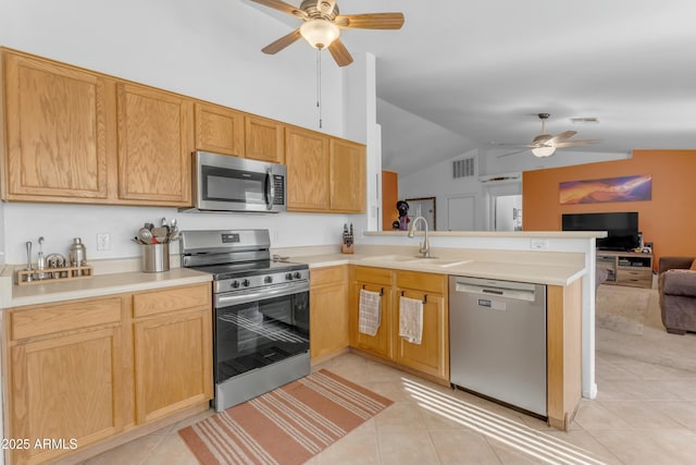 kitchen with stainless steel appliances, sink, light tile patterned floors, and kitchen peninsula