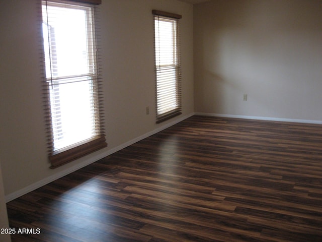 unfurnished room with dark hardwood / wood-style flooring