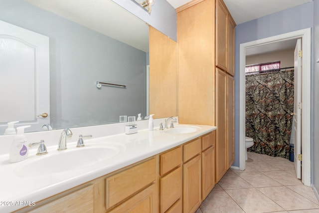 full bathroom featuring double vanity, a sink, tile patterned floors, and toilet