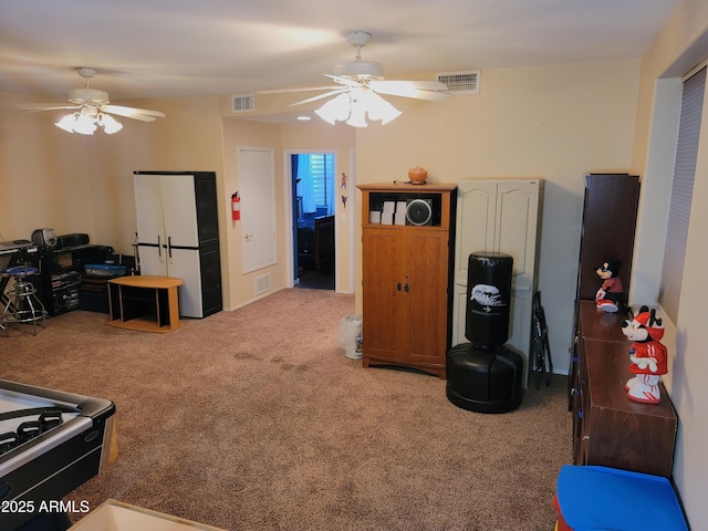 interior space featuring visible vents, ceiling fan, and light carpet