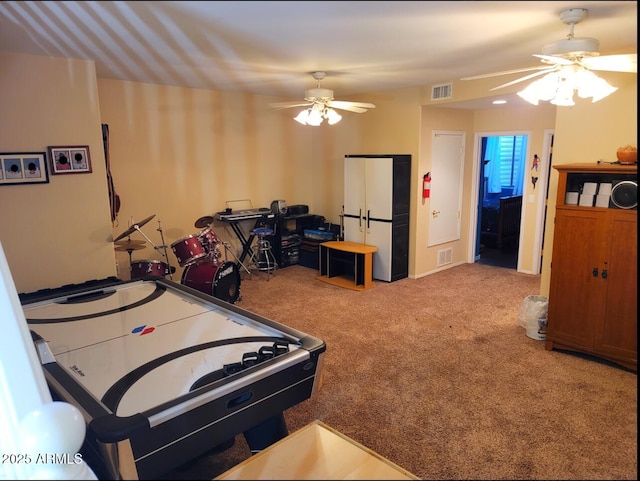 rec room featuring visible vents, a ceiling fan, and carpet floors