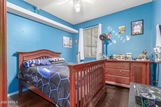 bedroom with a textured wall, ceiling fan, and wood finished floors