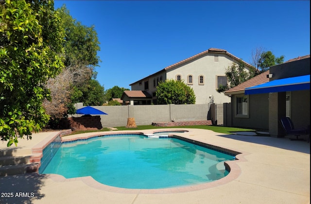 view of pool featuring a patio, a fenced backyard, and a pool with connected hot tub