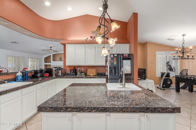kitchen with stainless steel refrigerator with ice dispenser, vaulted ceiling, a sink, light tile patterned floors, and white cabinets
