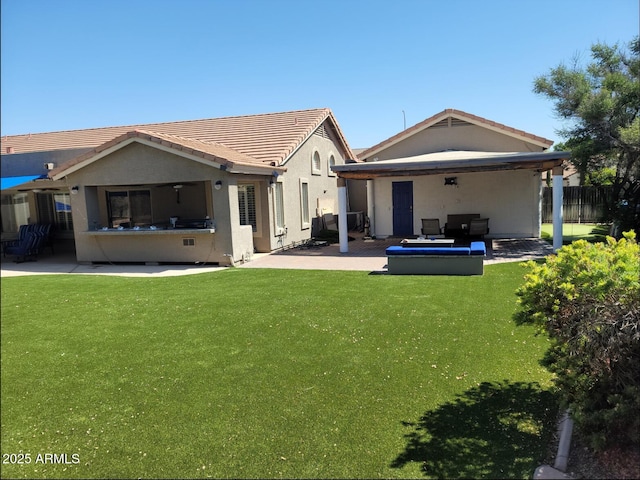 rear view of house with a tiled roof, a lawn, a patio area, fence, and stucco siding