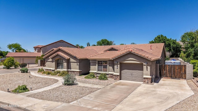 view of front of home featuring an attached garage, concrete driveway, stucco siding, and fence
