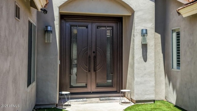 property entrance with french doors and stucco siding