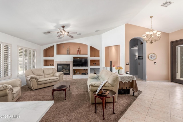 living room featuring arched walkways, visible vents, lofted ceiling, and ceiling fan with notable chandelier